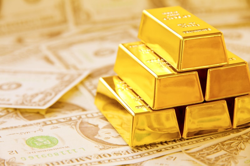 gold bars on dollar bills