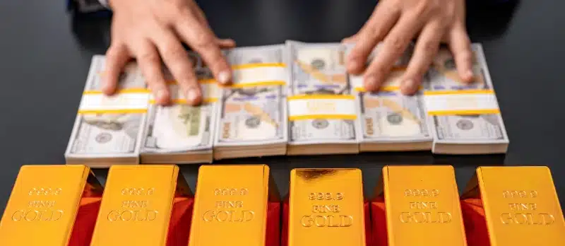 gold bars and stacks of $100 bills