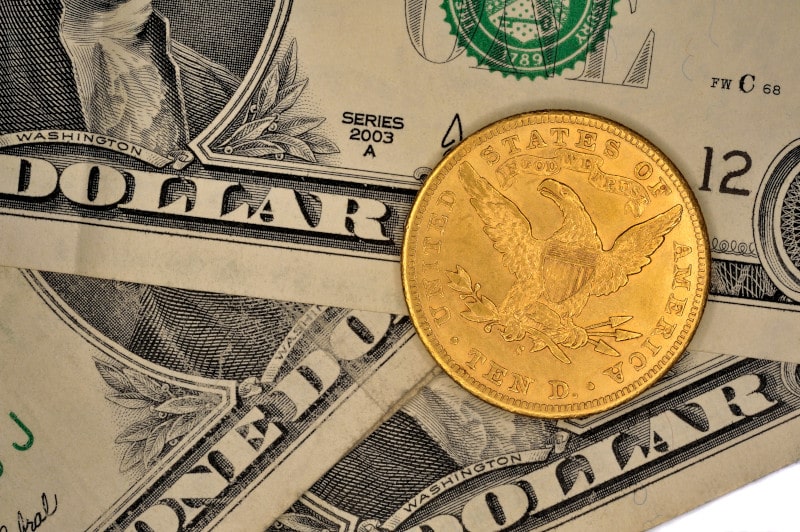 ten dollar gold coin with dollar bills