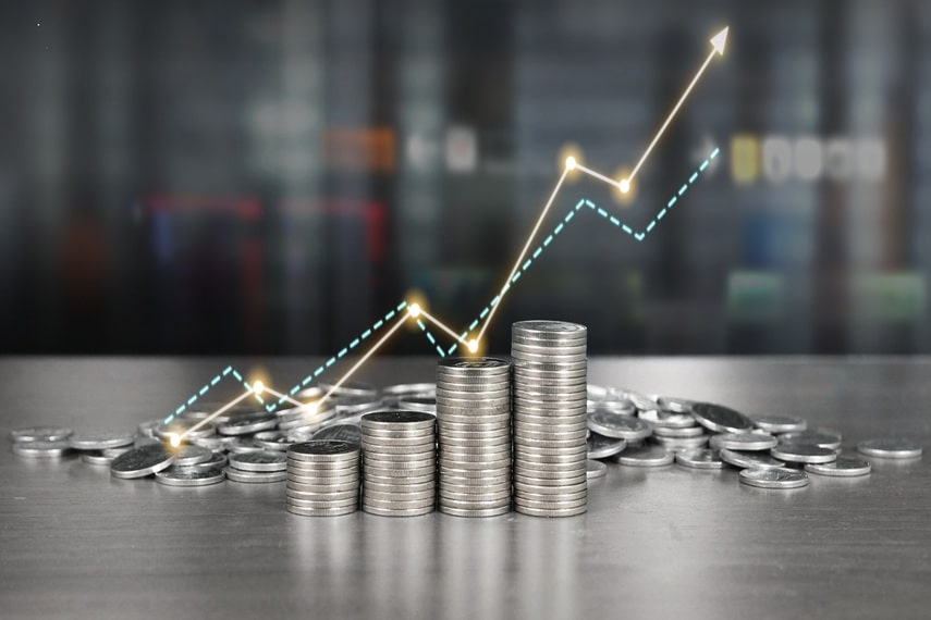 Silver coins stacked with a graph trending up