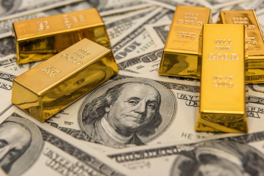 gold bars with dollar bills