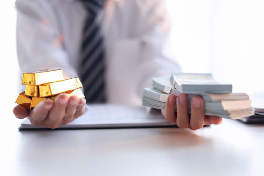 Man Holding gold bars and cash